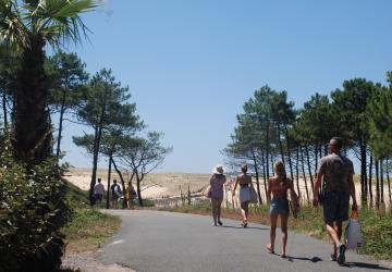 Vacanciers se rendant à la plage en traversant la dune par le chemin d'accès direct depuis le camping