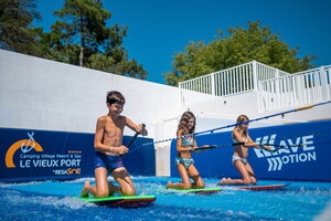 Enfants sur le simulateur de vague du camping 5 étoiles Le Vieux Port dans les Landes