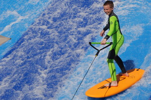 Enfant sur le simulateur de vagues dans le parc aquatique du camping 5 étoiles Le Vieux Port dans les Landes