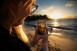 femme blonde téléphone plage coucher de soleil 