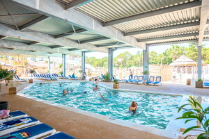 Camping avec piscine couverte et chauffée dans les Landes (2) vue des transats sur le parc aquatique par temps ensoleillé