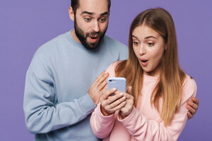 Camping avec application mobile dans les Landes (3) image d'un père et de sa fille surpris avec un téléphone en main isolés dans un fond violet