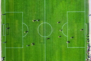 Camping avec terrain de football dans les Landes (1) vue drone du dessous d'un terrain de foot sur gazon avec personnes disputant un match