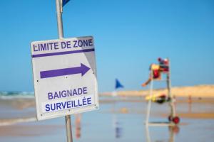 Camping avec accès direct à la plage en bord de mer (8) mat de drapeau bleu des maitres nageurs indiquant la limite de zone de la baignade surveillée avec mns sur leur chaise de surveillance