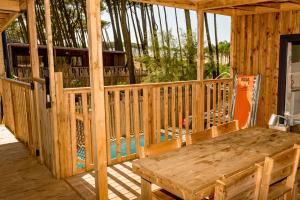 Votre location camping avec piscine privative dans un camping 5 étoiles (11) la table à manger sur la terrasse extérieure donne sur les 2 ouvertures de l'habitation et le mini parc aquatique