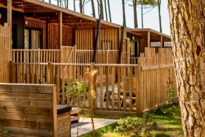 Votre location camping avec piscine privative dans un camping 5 étoiles (7) le petit salon en bois VIP privé donne sur la terrasse où le bassin d'eau chauffé à 28° se situe