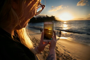 femme blonde téléphone plage coucher de soleil 