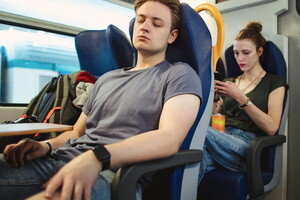 Un groupe de campeurs se reposant avant de débarquer d'un train à la gare, avec leurs bagages et équipements de camping, prêts pour une aventure en plein air.